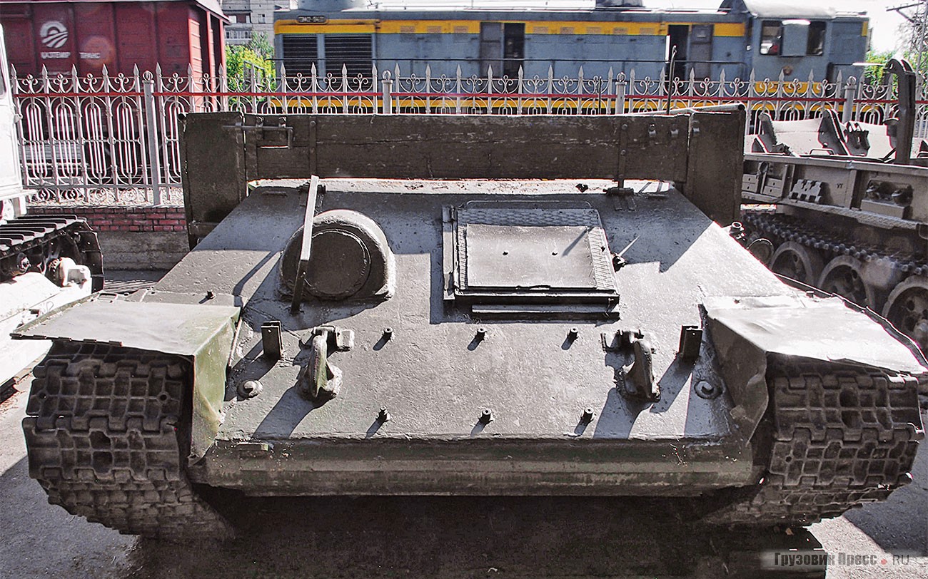 [b]Средний танковый тягач Т-34-Т[/b] на базе танка Т-34. Такие делали на танкоремонтных заводах Министерства обороны на основе «тридцатьчетвёрок» со снятым вооружением. Погон башни заваривали бронелистом, устанавливали такелажное оборудование и грузовую платформу. Подобные машины находятся в «зоне риска»: их выпустили мало, они не столь привлекательны для музеев, как танки, и велика вероятность, что вообще не дойдут для потомков