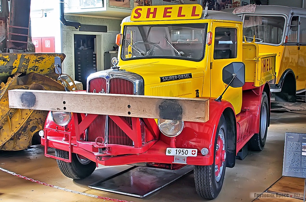 Промышленный тягач [b]Saurer 2CR1D[/b], 1948 г. Использовался в качестве маневрового локомотива компанией по продаже нефтепродуктов Lumina AG, в 1949 г. поглощённой корпорацией Shell. Оснащён рядным 5,32-литровым четырёхцилиндровым дизелем мощностью 75 л.с. Скорость – 45 км/ч.